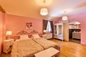 a bedroom with a large bed with pink walls at Clos De La Gourmandière in Saint-Lothain
