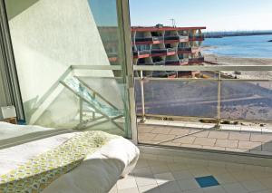 a bedroom with a balcony with a view of the beach at Superbe appartement sur la plage - Le Zénith in Palavas-les-Flots