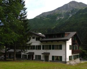 a building with a mountain in the background at Casa Alpina Don Guanella in Macugnaga