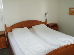a white bed in a bedroom with two night stands at Hotell Dalsland in Ed