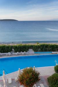 a swimming pool with a view of the ocean at The Grove Seaside Hotel in Drepana