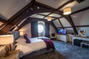 a bedroom with an arched ceiling with a bed and a desk at St Nicholas Boutique Hotel in Shrewsbury