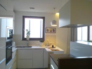 ワルシャワにあるLuxury Apartment - Hoza 55の白いキャビネット、シンク、窓付きのキッチン