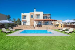 a villa with a swimming pool in front of a house at MarySol Luxury Villa in Gennadi