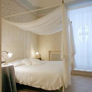 a bedroom with a white bed and a window at Villaggio In Case Sparse Nel Centro Storico in Martina Franca