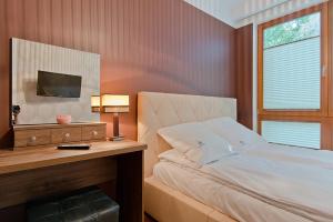 ソポトにあるImperial Apartments Aquarius IIIのベッドルーム1室(ベッド1台、デスク、テレビ付)