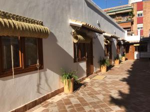 ein Gebäude mit Topfpflanzen an der Seite in der Unterkunft La Quinta Hacienda in Córdoba