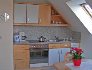 - une cuisine avec des placards en bois, un évier et une cuisinière dans l'établissement Urlaub am Bauernhof Hans im Winkel, à Wenigzell