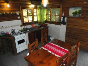 La cocina está equipada con fogones, mesa y fogones. horno superior en Tierra Ventana - Casas de Montaña, en Sierra de la Ventana