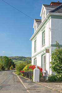 a white house on the side of a street at Llety Brynawel Guest House in Pennal