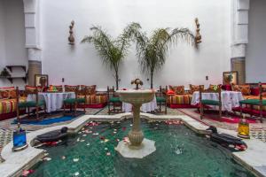 a fountain in the middle of a room with tables and chairs at Riad Lalla Zoubida in Fès