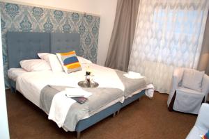 pokój hotelowy z łóżkiem i krzesłem w obiekcie Acwador w mieście Pleszew