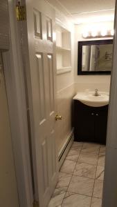a bathroom with a sink and a white door at Atlantic Motel in Point Pleasant Beach