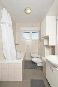 a bathroom with two sinks and a tub and two toilets at Apartment Caprice in Zadar +63 photos