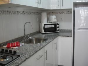 a kitchen with a sink and a microwave at Terraced House - Zand Properties in Benidorm