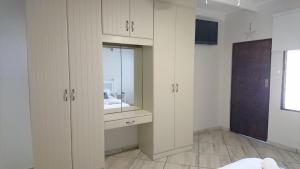een badkamer met witte kasten en een wastafel bij Beach House 22 - Manzini Chalets in St Lucia