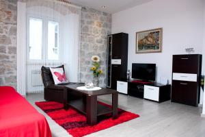 ein Wohnzimmer mit einem Sofa und einem TV in der Unterkunft Apartman u srcu grada - Ilićev prolaz in Split