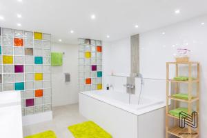 un bagno con vasca e piastrelle colorate sul muro di Iddup Atrium a Oreye