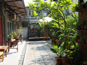 バンコクにあるSriyanar Placeの植物とテーブル、ベンチのある中庭