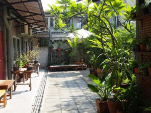 un patio con plantas, mesas y bancos en Sriyanar Place en Bangkok