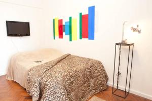 Habitación con cama y TV en la pared. en Lapa I Cultura Museus e Praias no Centro GR, en Río de Janeiro