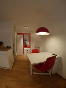 バンベルクにあるHaus "Zum Schwarzen Stiefel"の白いテーブルと赤い椅子2脚が備わる客室です。