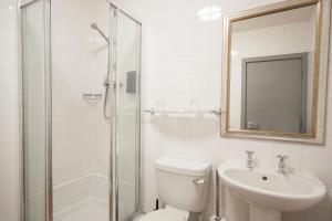
a bathroom with a shower, sink, and mirror at The Cathedral Hotel in Salisbury
