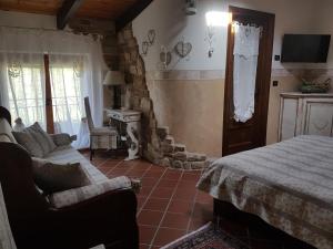 sypialnia z łóżkiem, kanapą i kominkiem w obiekcie Bed And Breakfast Olimpia w mieście San Salvatore Monferrato