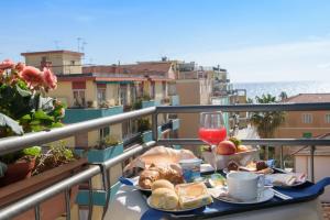 un tavolo con cibo e un bicchiere di vino sul balcone di Hotel Ristorante La Marina Mhotelsgroup a San Bartolomeo al Mare