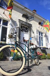 een blauwe fiets geparkeerd voor een huis bij Horenbecca Bistro & Wellness in Horebeke
