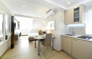 a kitchen and living room with a table and chairs at D&G Apartments Zagreb in Zagreb