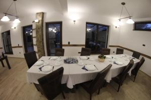 une salle à manger avec une table et des chaises blanches dans l'établissement Casa Laur cu plajă privată, à Colibiţa