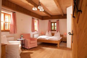 ein Schlafzimmer mit einem Bett und einem Stuhl in einem Zimmer in der Unterkunft Zehna Hube in Semriach