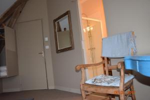 einen Schaukelstuhl aus Holz in einem Zimmer mit Spiegel in der Unterkunft Le Briou in Précy
