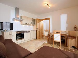 a living room with a couch and a kitchen with a table at Landhaus Lindner in Westendorf