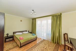 a bedroom with a bed and a large window at Apartments Sonce in Truskavets