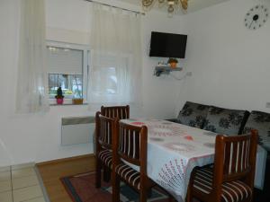 a room with a table and chairs and a tv at Vacation Home Katarina in Čapljina