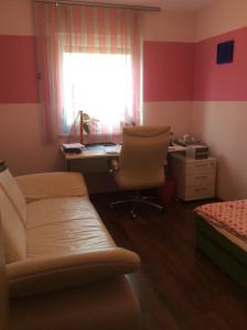 a bedroom with a couch and a desk and a window at Lakeside Villa in Frauenkirchen