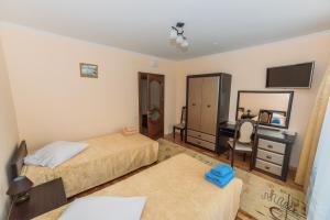 a bedroom with two beds and a desk and a mirror at Apartments Sonce in Truskavets