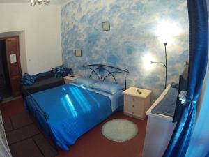 1 dormitorio con cama azul y pared azul en Eco B&B I Due Oleandri, en Marina di Carrara