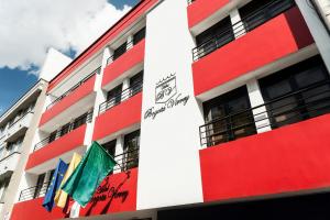 um edifício vermelho e branco com bandeiras em Hotel Bogota Virrey em Bogotá