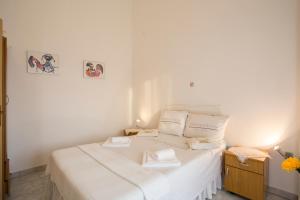 a bedroom with a white bed with two towels on it at Guest House Croatia in Fažana