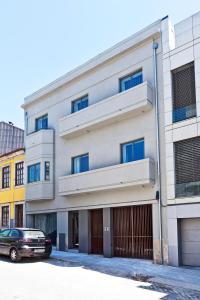 un bâtiment avec une voiture garée devant lui dans l'établissement bnapartments Palacio, à Porto