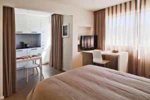 a hotel room with a bed and a desk and a television at bnapartments Palacio in Porto