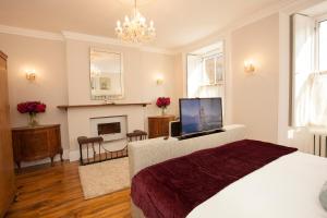 a bedroom with a bed with a television and a fireplace at Victoria House in Stow on the Wold