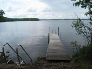 a dock in the middle of a large lake at Matila's Cottages in Sumiainen