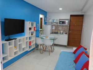 a living room with a tv and a dining room at Terrazzas Flat in João Pessoa