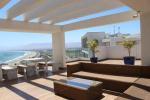 sala de estar con sofá y vistas al océano en Club Oceano, en Coquimbo