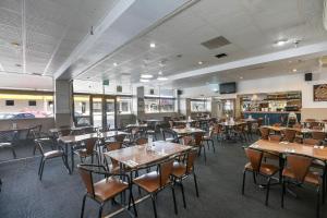 a restaurant with tables, chairs, and tables at The Union Club Hotel in Colac