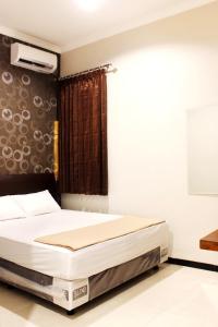 a bedroom with a bed and a window with a projector at House of Dharmawan in Surabaya